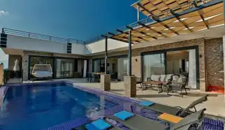 Kalkan Çavdır Köyünde konumlanan içerisinde ısıtmalı iç havuz, jakuzi, sauna, hamama sahip Ultra Lüksk Kiralık Tatil Villası Villa Lalezar üç yatak odalı